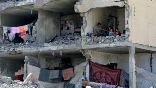 Une famille palestinienne dans une pièce détruite par une frappe israélienne à Rafah, dans le sud de la bande de Gaza, le 22 mai 2024  ( AFP / Eyad BABA )