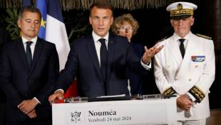 Le président Emmanuel Macron (c) prononce un discours entouré du ministre de l'Intérieur Gérald Darmanin (g) et du haut-commissaire de la Nouvelle-Calédonie Louis Le Franc, le 24 mai 2024 à Nouméa ( POOL / Ludovic MARIN )