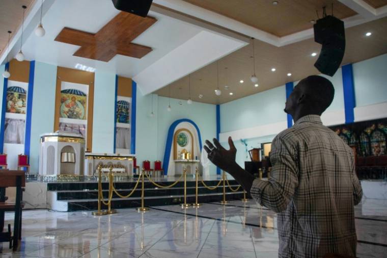Un homme prie dans une église à Port-au-Prince, le 29 mars 2024 en Haïti ( AFP / Clarens SIFFROY )