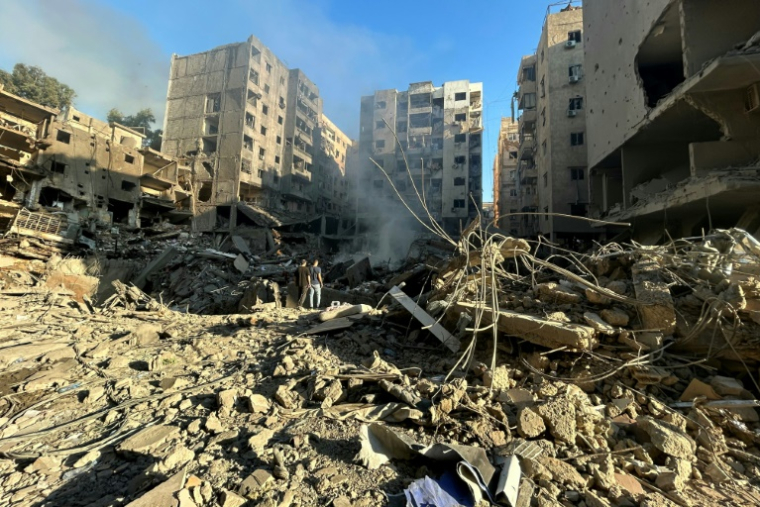 Des Libanais au milieu des destructions provoquées par les bombardements israéliens dans la banlieue sud de Beyrouth, le 28 septembre 2024 ( AFP / ANWAR AMRO )