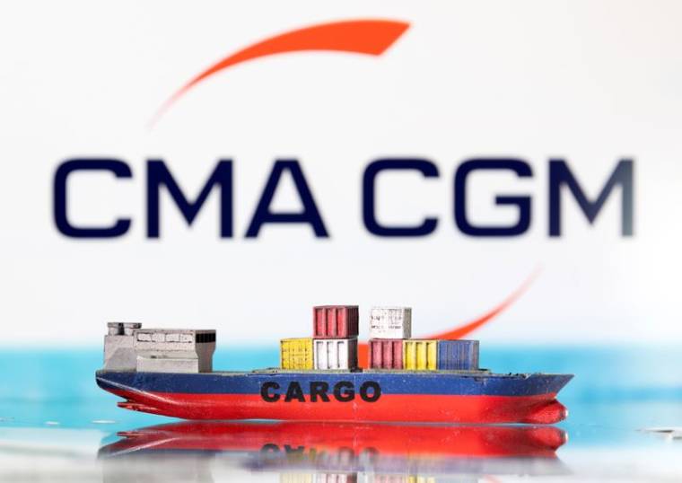 Photo d'illustration d'un modèle de bateau cargo devant le logo de CMA CGM