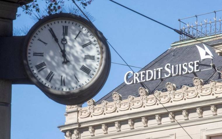 Une horloge près du logo de la banque Credit Suisse sur la place Paradeplatz à Zurich, Suisse