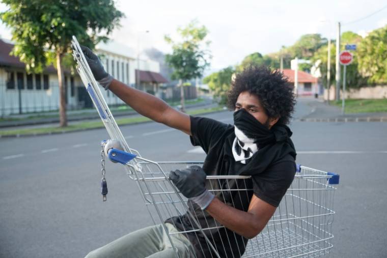 Un résident du quartier de la Vallée-du-Tir à Nouméa observe la barricade dressée par des habitants à Nouméa, en Nouvelle-Calédonie le 16 mai 2024 ( AFP / Delphine Mayeur )
