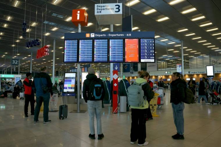 Des voyageurs consultent des panneaux d'information sur les vols à l'aéroport d'Orly, près de Paris, pendant une grève des contrôleurs aériens, le 25 avril 2024 ( AFP / Thomas SAMSON )