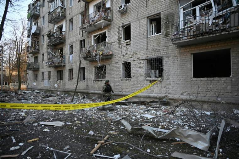 Un secouriste travaille devant un immeuble résidentiel endommagé par les frappes russes à Kharkiv, le 27 mars 2024 ( AFP / SERGEY BOBOK )