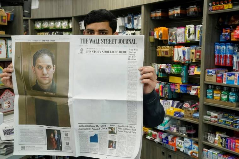 Un vendeur de New York avec un exemplaire du Wall Street Journal et la photo de Evan Gershkovich, le 29 mars 2024 ( AFP / TIMOTHY A. CLARY )
