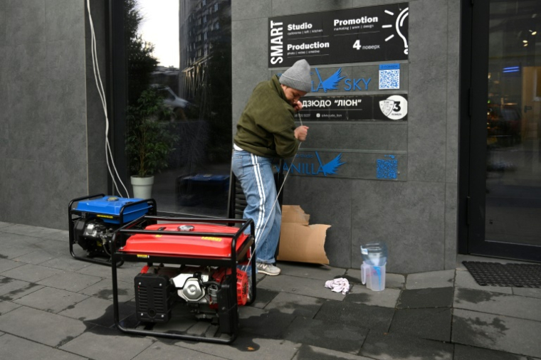 Un habitant démarre un générateur électrique lors d'une panne de courant à Lviv, le 28 novembre 2024 en Ukraine (AFP / YURIY DYACHYSHYN)