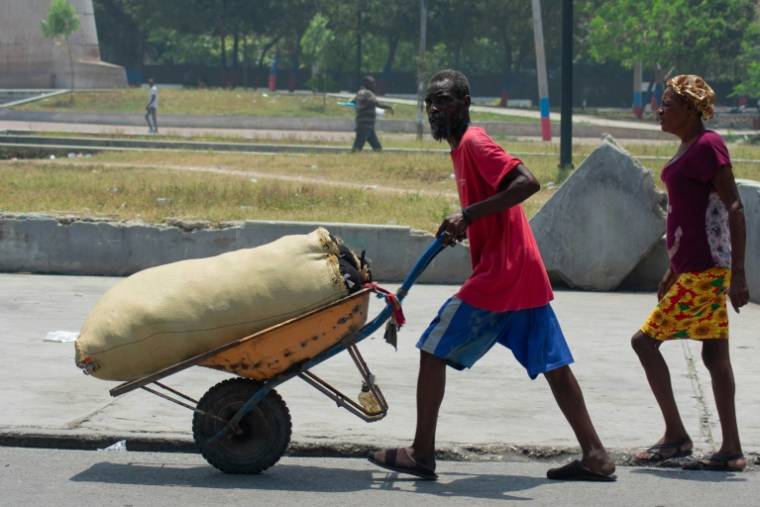 Des vendeurs ambulants fuient la violence des gangs, le 8 avril 2024 à Port-au-Prince, en Haïti ( AFP / Clarens SIFFROY )