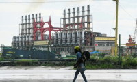 Un Cubain marche à côté d'une centrale électrique flottante dans le port de La Havane, le 21 octobre 2024 ( AFP / YAMIL LAGE )