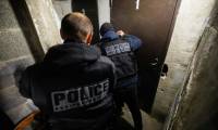 Un policier de l'unité canine et un policier spécialisé dans la recherche de drogues, armes et  munitions participent à l'opération "Place nette" dans le quartier nord de "Font-Vert", le 29 novembre 2023 à Marseille ( AFP / CLEMENT MAHOUDEAU )