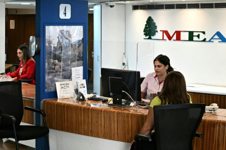 Une cliente tente d'acheter un billet d'avion dans les bureaux de la compagnie Middle East Airlines à Beyrouth, le 27 septembre 2024 au Liban ( AFP / Joseph EID )