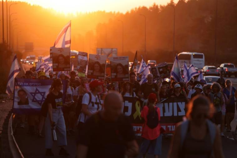 Des personnes marchent en direction de Jérusalem pour tenter de faire pression sur le gouvernement israélien afin qu'il négocie un accord pour libérer les otages retenus dans la bande de Gaza depuis l'attaque du Hamas le 7 octobre, le 11 juillet 2024 ( AFP / Menahem KAHANA )