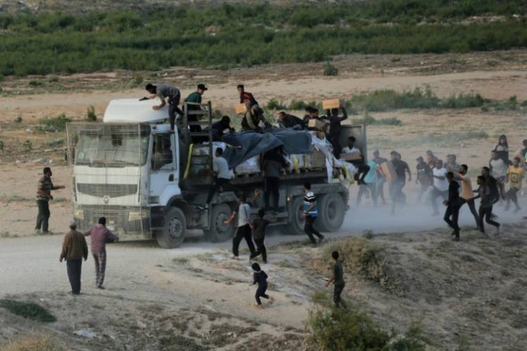 Des palestiniens se ruent sur un camion d'aide humanitaire le 18 mai 2024 près de Nousseirat, dans le centre de la bande de Gaza, où une guerre oppose Israël au mouvement islamiste palestinien Hamas ( AFP / - )