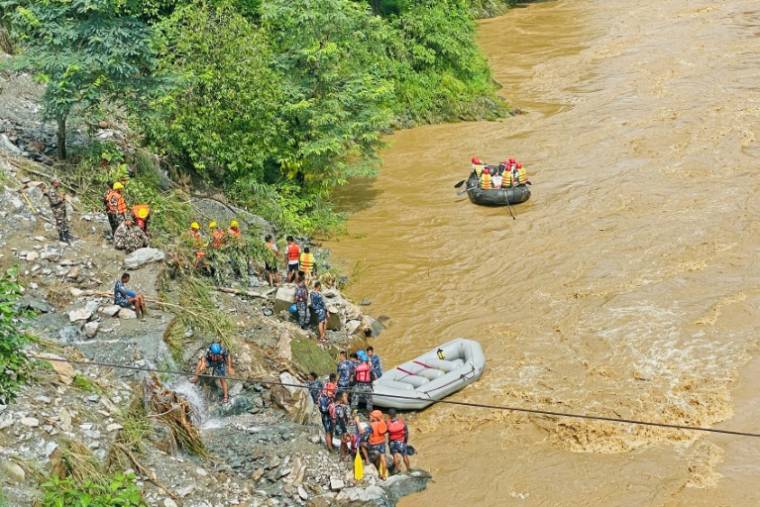 Des équipes de secours recherchent des survivants dans la rivière Trishuli après un glissement de terrain qui a emporté deux bus, le 12 juillet 2024 à Simaltar, au Népal ( AFP / RAJESH GHIMIRE )