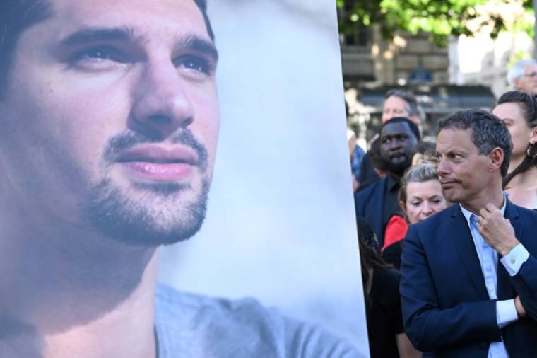 Marc-Olivier Fogiel et le portrait du journaliste tué en Ukraine Frédéric Leclerc-Imhoff, lors d'un rassemblement hommage sur la place de la République à Paris, le 10 juin 2022 ( AFP / Bertrand GUAY )
