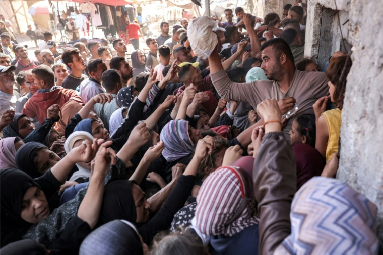 Les Gazaouis se rassemblent devant une boulangerie à Khan Younes, au sud de la bande de Gaza, le 23 octobre 2024 (AFP / BASHAR TALEB)