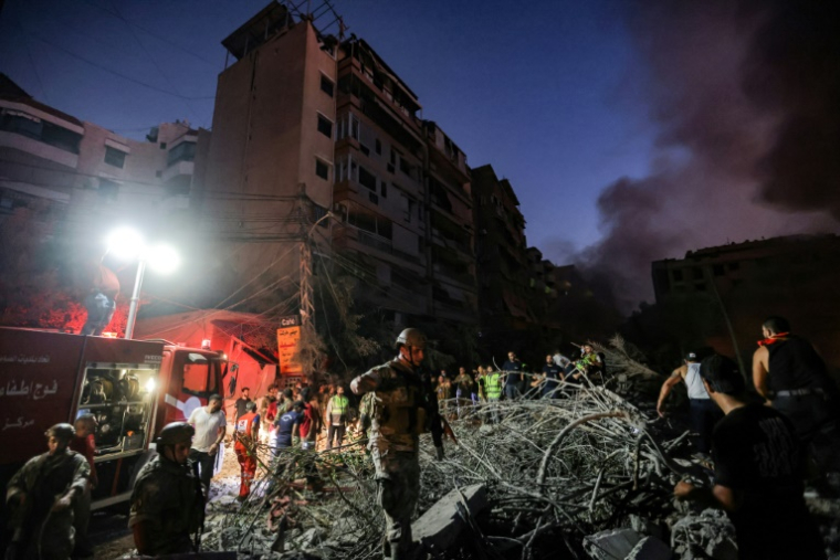 Des soldats libanais sur les décombres laissés par une frappe israélienne visant le QG du Hezbollah, dans la  banlieue sud de Beyrouth, le 27 septembre 2024 ( AFP / Ibrahim AMRO )