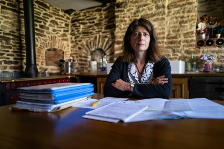 Sophie Rollet chez elle, avec les dossiers sur ses recherches concernant l'explosion de pneus qui a causé la mort de son mari, Jean-Paul Rollet, en 2014, le 9 juillet 2020 à Geney, dans le Doubs ( AFP / SEBASTIEN BOZON )