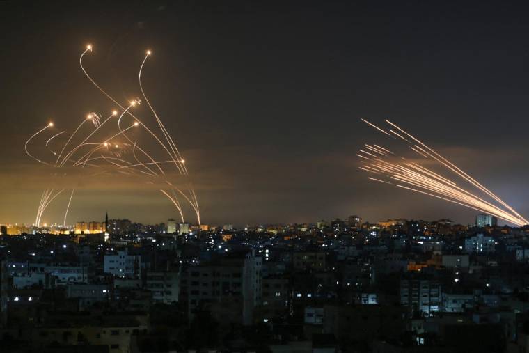 Le système de défense antimissile israélien Iron Dome, à gauche, intercepte les roquettes tirées par le Hamas, à droite, vers le sud d'Israël depuis Beit Lahia dans le nord de la bande de Gaza, pendant la nuit du 14 mai 2021.  ( AFP / ANAS BABA )