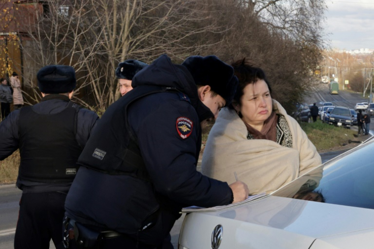 Un policier russe note le témoignage d'une habitante du village de Stanovoïe, dans la région de Moscou, suite à une attaque de drones, le 10 novembre 2024 ( AFP / TATYANA MAKEYEVA )