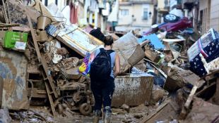 Une habitante dans une rue bloquée par des débris et des épaves de voitures à Paiporta, après des inondations meurtrières dans la région de Valence, le 4 novembre 2024 en Espagne ( AFP / JOSE JORDAN )