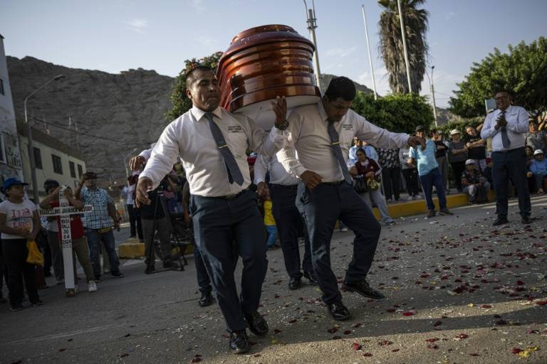 Des porteurs funéraires dansent en transportant le cercueil de Marcelino Jamanca lors de ses funérailles à Huacho, le 2 mai 2024 au Pérou ( AFP / Ernesto BENAVIDES )