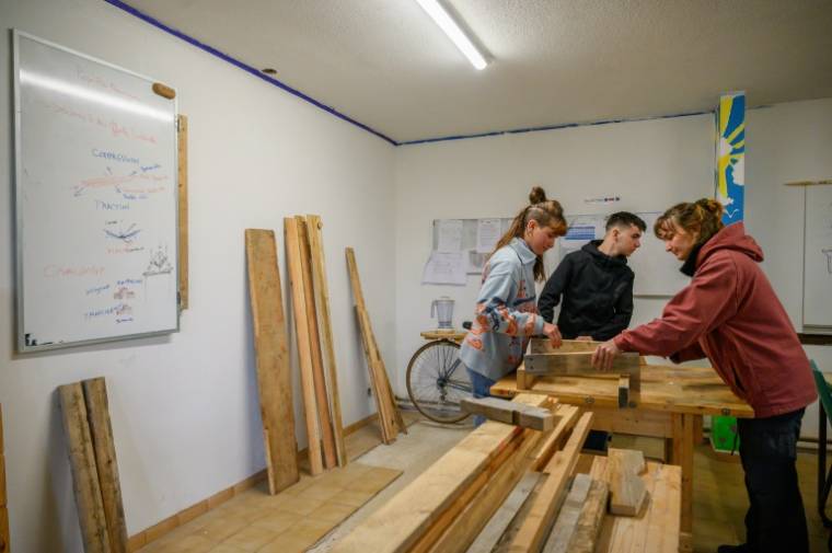 Des élèves lors d'un atelier de menuiserie à l'école de la transition écologique (ETRE) de Lahage, près de Toulouse, le 18 avril 2024 ( AFP / Ed JONES )