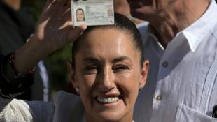 Claudia Sheinbaum, candidate à la présidentielle, montre sa carte d'électrice, le 2 juin 2024 à Mexico ( AFP / CARL DE SOUZA )