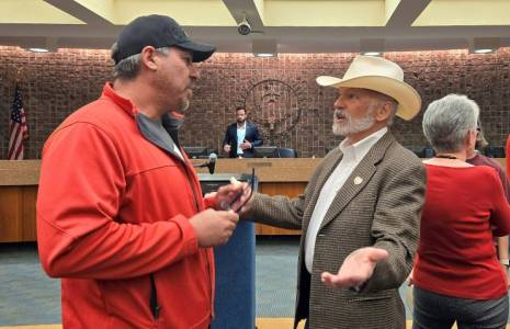 John Barrett (à droite) un habitant conservateur d'Amarillo, discute avec un autre habitant lors d'une session du conseil municipal de cette ville du Texas, le 28 mai 2024 ( AFP / Moisés ÁVILA )