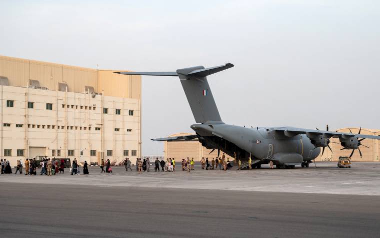 Des exfiltrés de Kaboul s'apprêtent à monter dans un avion militaire français en direction de Paris, le 23 août 2021. ( AFP / BERTRAND GUAY )