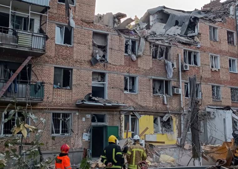 Des sauveteurs travaillent sur le site d'un immeuble d'habitation endommagé par une frappe russe à Mykolaïv