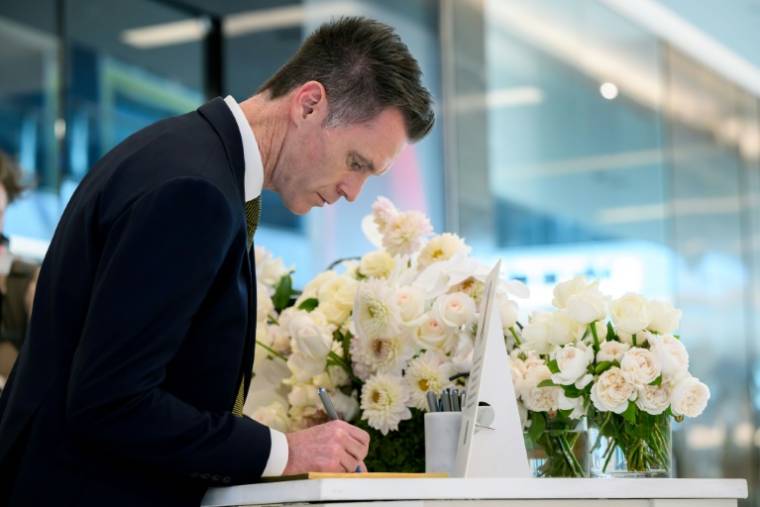 Le chef du gouvernement de la Nouvelle-Galles du Sud Chris Minns signe un livre de condoléances lors de la réouverture du centre commercial Westfield Bondi Junction à Sydney, le 18 avril 2024 ( POOL / BIANCA DE MARCHI )