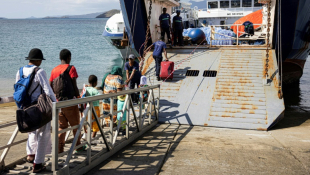 Des passagers embarquent à Dzaoudzi (Mayotte) en direction des Comores le 28 décembre 2024 ( AFP / PATRICK MEINHARDT )