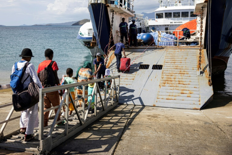 Des passagers embarquent à Dzaoudzi (Mayotte) en direction des Comores le 28 décembre 2024 ( AFP / PATRICK MEINHARDT )