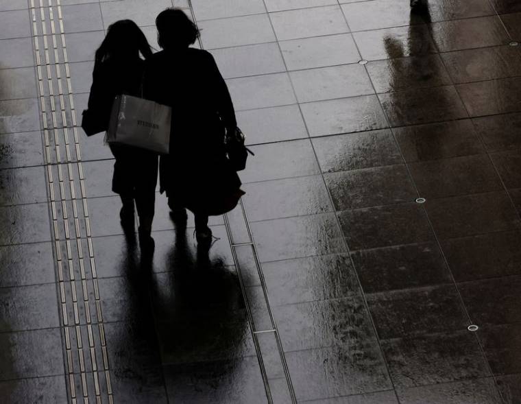 Des femmes portant un sac de courses dans un quartier commerçant de Tokyo
