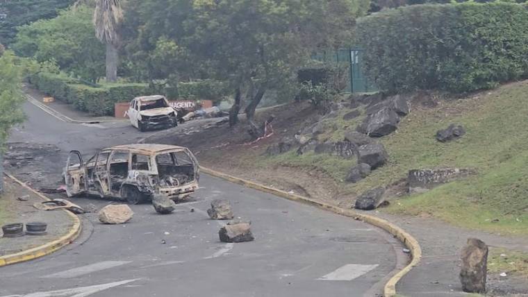Des voitures brûlées sur une route de Nouméa