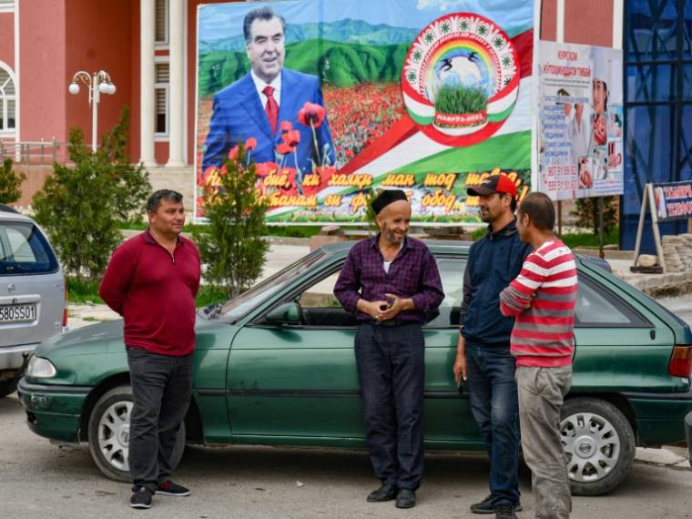 Des hommes bavardent devant un portrait du président du Tadjikistan, Emomali Rakhmon, dans le district de Khourosson, le 26 mars 2024 ( AFP / - )