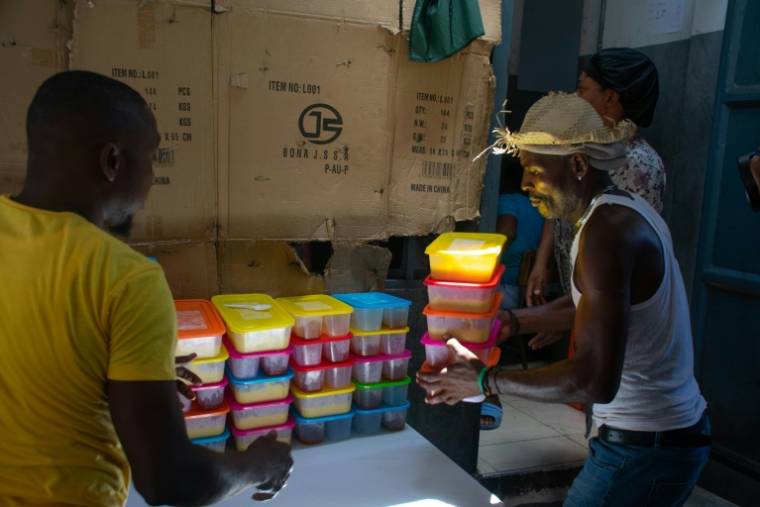 Distribution de nourriture dans une école devenue un refuge pour personnes déplacées par la violence, à Port-au-Prince le 22 avril 2024 ( AFP / Clarens SIFFROY )
