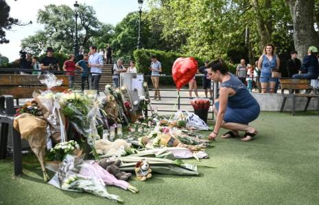 Une femme dépose des fleurs dans le parc "Les jardins de l'Europe", le lendemain d'une attaque au couteau, le 9 juin 2023 à Annecy ( AFP / OLIVIER CHASSIGNOLE )