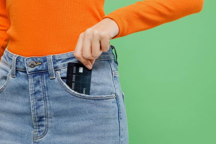 (Crédits photo : Adobe Stock - Femme plaçant sa carte bancaire dans la poche)