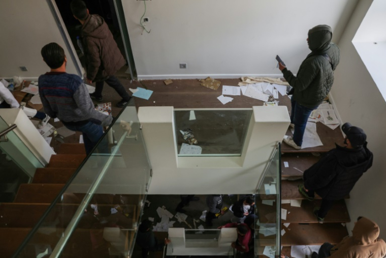 Des personnes dans une des pièces de la résidence du président syrien déchu Bachar al-Assad, dans le quartier Malki à Damas, le 8 décembre 2024 ( AFP / OMAR HAJ KADOUR )