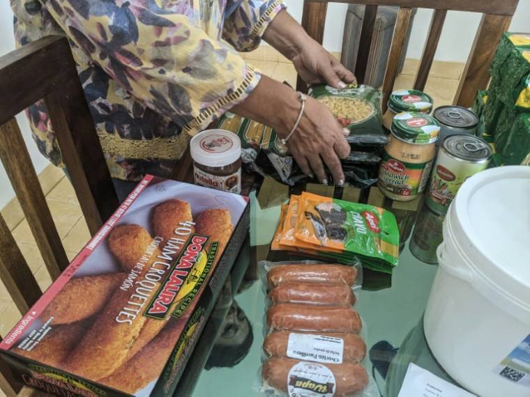 La Cubaine Maria Paez range la nourriture envoyée depuis Miami par ses enfants exilés, le 16 mai 2024 à La Havane  ( AFP / STRINGER )