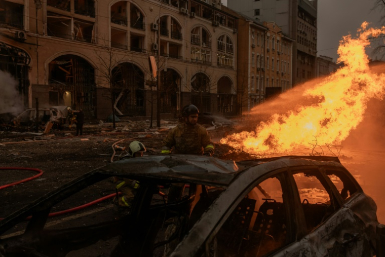 Des secouristes ukrainiens essaient d'éteindre un incendie sur les lieux d'une attaque de missiles russes, à Kiev, le 20 décembre 2024 ( AFP / Roman PILIPEY )