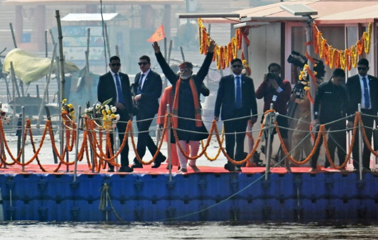 Le Premier ministre indien Narendra Modi (c) salue la foule après avoir plongé dans les eaux des fleuves sacrés du Gange, de la Yamuna et de la mythique Saraswati, lors du pèlerinage de la Kumbh Mela à Prayagraj, le 5 février 2025 ( AFP / Idrees MOHAMMED )