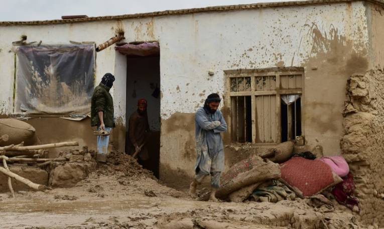 Des Afghans devant une maison ravagée par les crues subites qui ont touché le nord-est de l'Afghanistan, le 11 mai 2024 à Laqiha, dans la province de Baghlan  ( AFP / - )