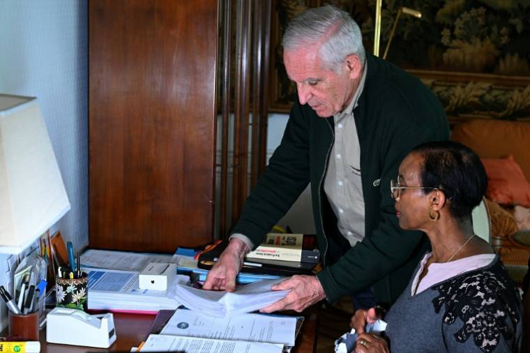 Alain Gauthier et son épouse Dafroza Mukarumongi-Gauthier, cofondateurs du Collectif des parties civiles pour le Rwanda, examinent des documents, chez eux, le 26 mars 2024 à Reims ( AFP / FRANCOIS NASCIMBENI )