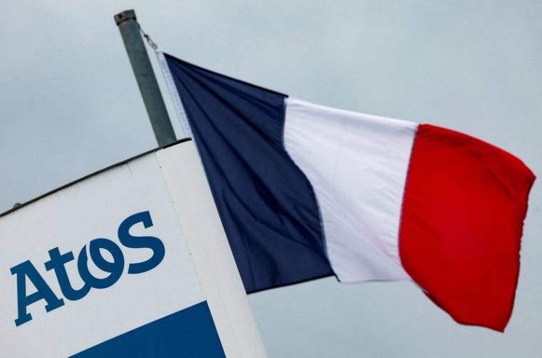 Drapeau national français et logo de la société française de conseil en informatique Atos, à l'entrée des locaux de la société, à Angers