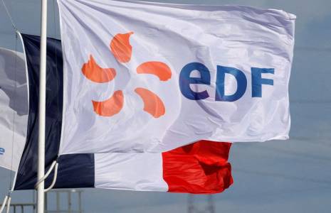Un drapeau portant le logo d'EDF et un drapeau français flottent à côté de la centrale EDF de Bouchain