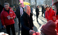 Le chancelier allemand Olaf Scholz (d) rencontre des électeurs alors qu'il fait campagne à Potsdam, la veille des élections législatives, le 22 février 2025 dans l'est de l'Allemagne ( AFP / RALF HIRSCHBERGER )