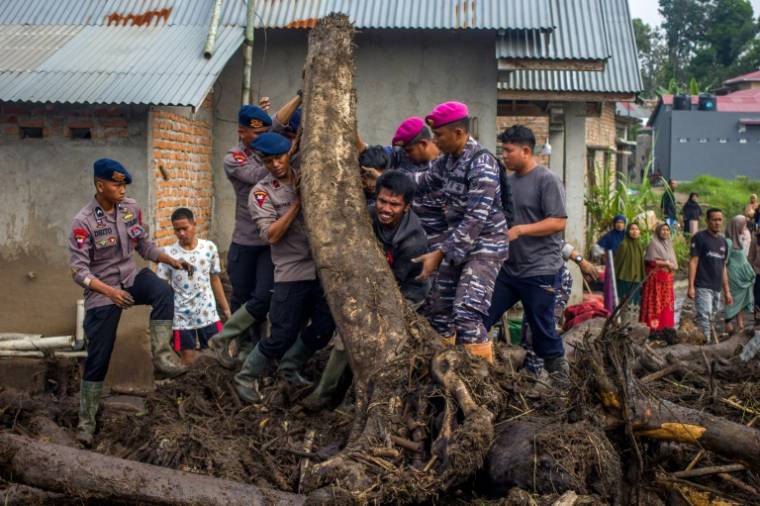 Des membres d'une équipe de secours et des habitants recherche des personnes disparues dans le village de Batu Taba, dans la province indonésienne d'Agam, dans l'ouest de l'île de Sumatra, le 14 mai 2024 ( AFP / REZAN SOLEH )